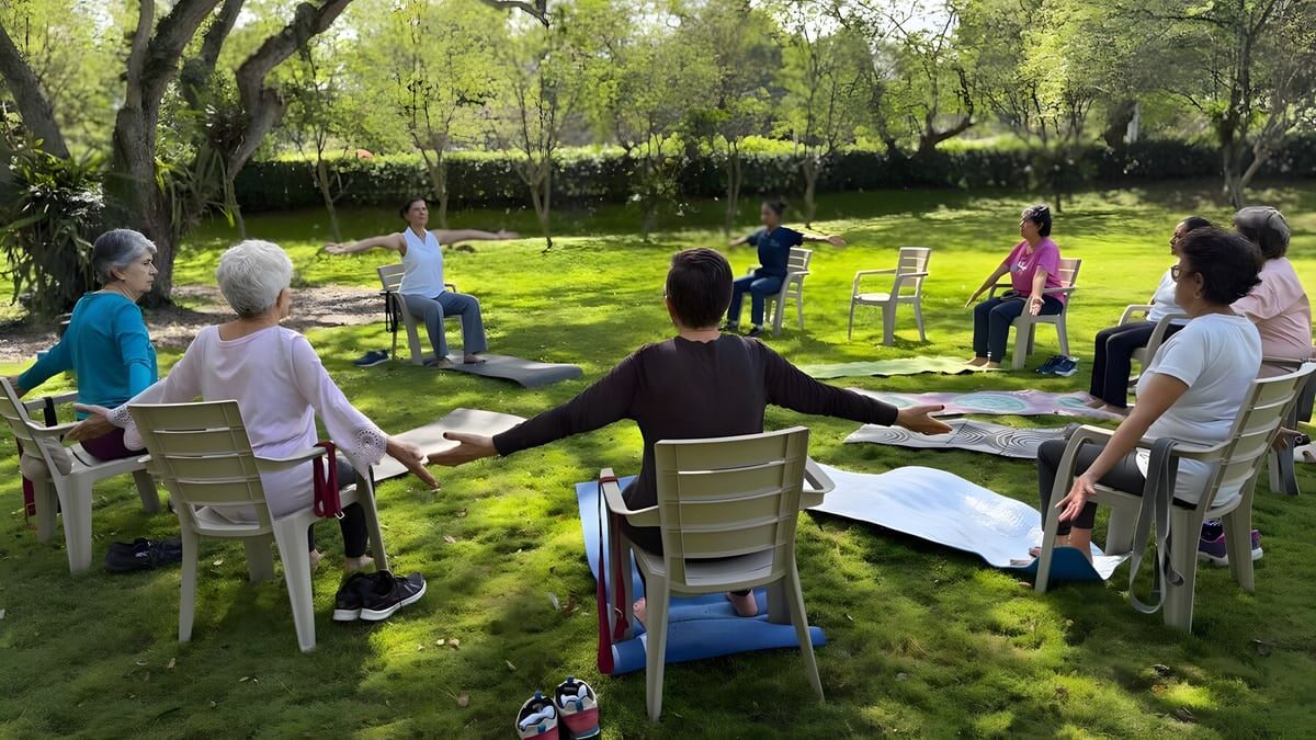 Grupo sentado en sillas puestas en círculo sobre el césped, con la instructora al frente.